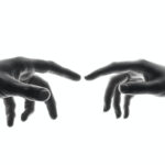 Dos manos enfrentadas a punto de tocarse con los dedos indices